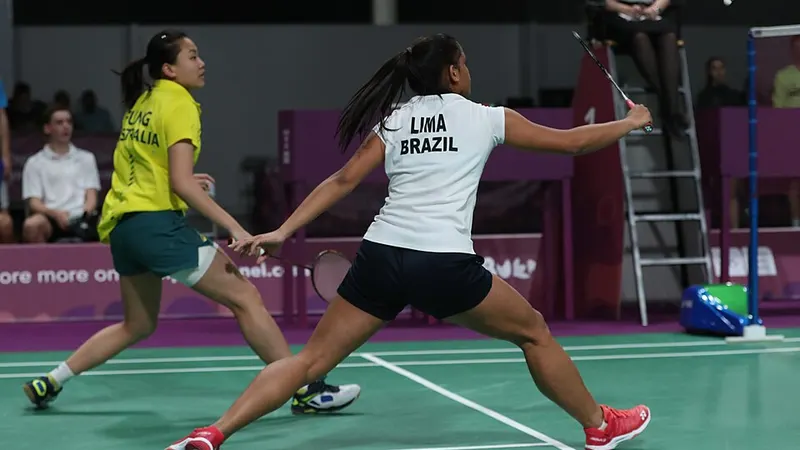 Badminton doubles players competing on an indoor court