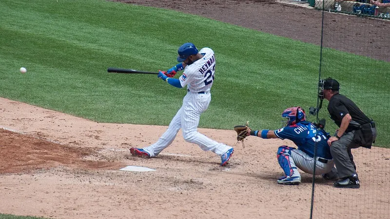 Baseball batter swinging with a catcher and umpire behind home plate
