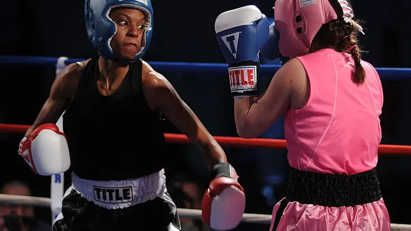 Two boxers sparring in gloves and protective headgear