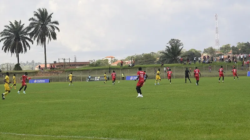 Football players competing on a grass pitch