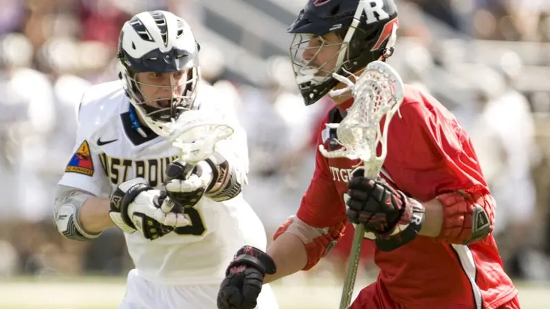 Two lacrosse players running with their sticks