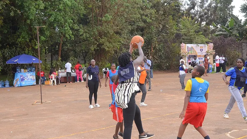 Netball players contesting a shot beneath the goal ring