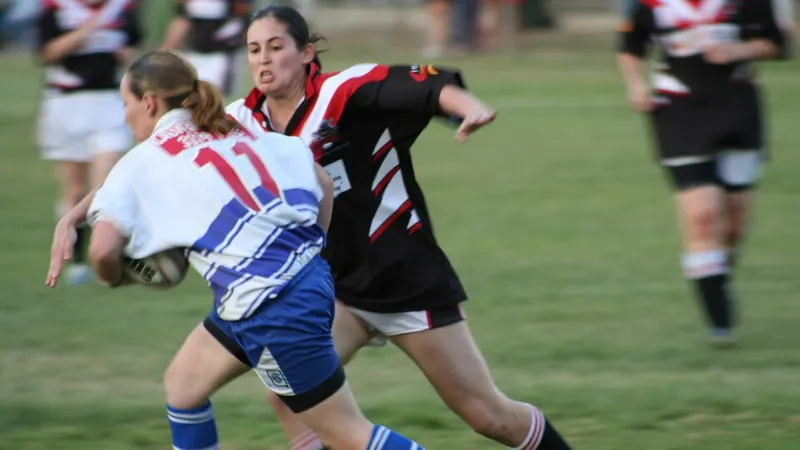 Rugby league players running with the ball during a tackle