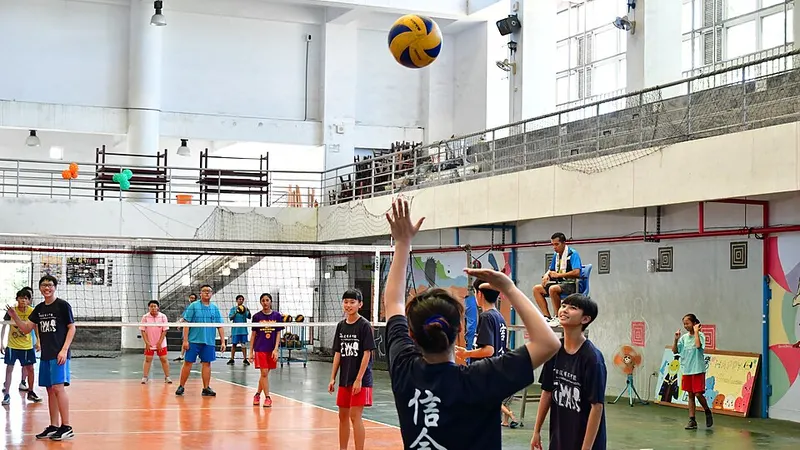 Volleyball teams contesting a ball at an indoor net